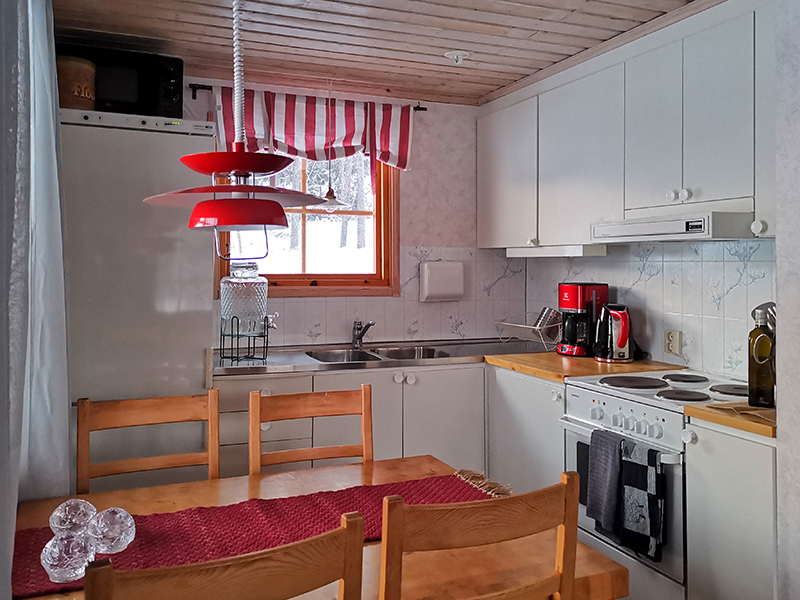 Stugans kök med kyl, frys, mikro, diskbänk, köksmaskiner och spis.  